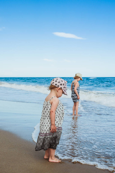 Imádnivaló kislányok séta a wateron a tengerparton, Földközi-tenger, Spanyolország - Fotó, kép