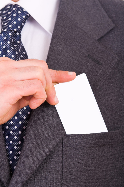 Businessman putting blank card in his pocket. - Фото, изображение
