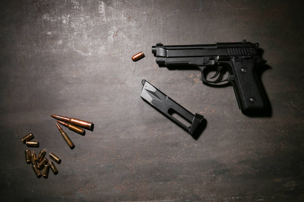 Pistola con balas sobre fondo gris
 - Foto, imagen
