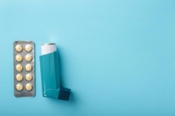 Inhalador y pastillas sobre fondo de color - Foto, imagen