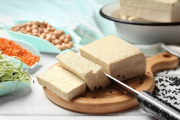 Cutting board with tasty tofu cheese on white table - Photo, Image