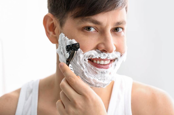 Bonito homem de barbear contra fundo branco
 - Foto, Imagem
