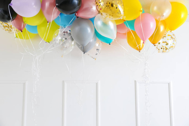 Bunte Geburtstagsballons unter der Decke im Zimmer - Foto, Bild