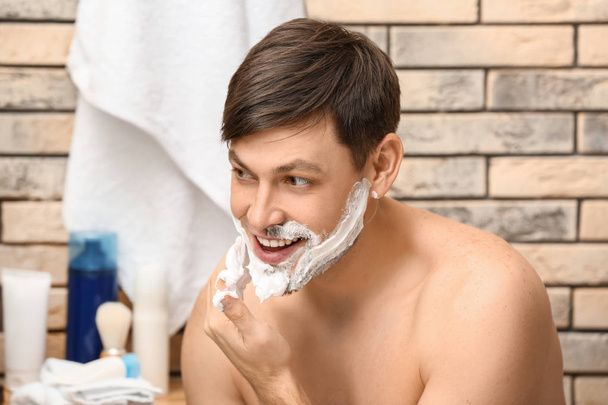 Bonito homem de barbear no banheiro
 - Foto, Imagem
