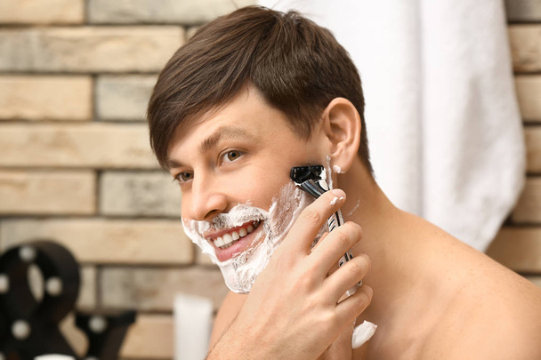 Jóképű férfi fürdőszoba borotválkozás - Fotó, kép