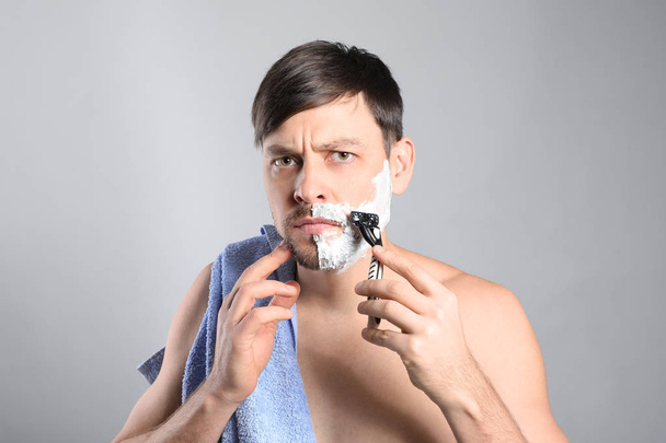 Jóképű férfi borotválkozási szürke háttér - Fotó, kép