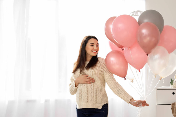 Красива вагітна жінка з повітряними кульками вдома
 - Фото, зображення