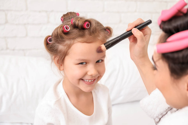 Mladá matka použití kosmetiky na obličej její roztomilé dcery doma - Fotografie, Obrázek