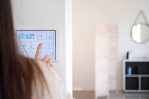 Young woman using application of smart home automation - Foto, Imagen