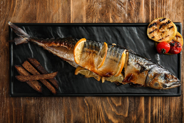 木製のテーブル上に美味しいサバ魚とプレート - 写真・画像