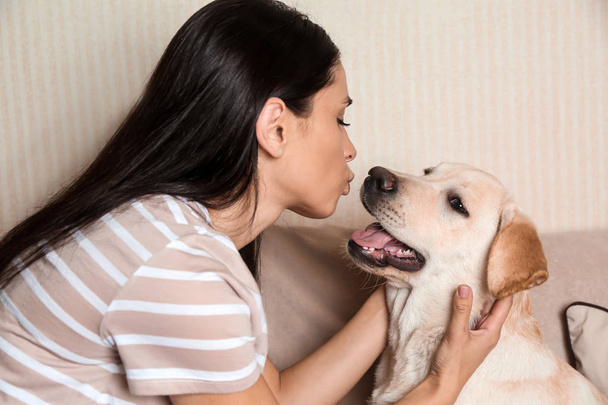 Portrait de jeune femme avec son chien labrador mignon à la maison
 - Photo, image