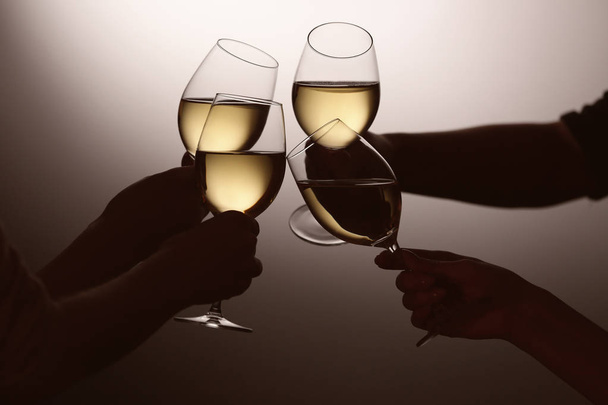 Mulheres batendo copos com vinho saboroso no fundo escuro
 - Foto, Imagem