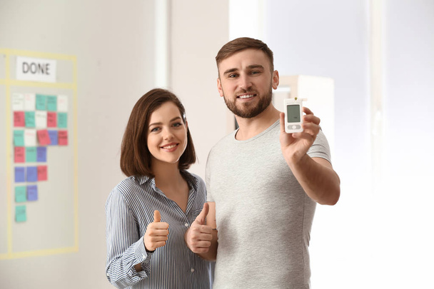 Couple avec glucomètre numérique montrant pouce à la maison
 - Photo, image