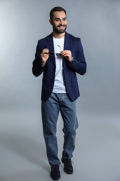Handsome fashionable man on grey background - Fotó, kép