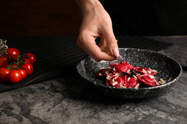 Küchenchef würzt schmackhafte Ravioli mit Kräutern auf Teller - Foto, Bild