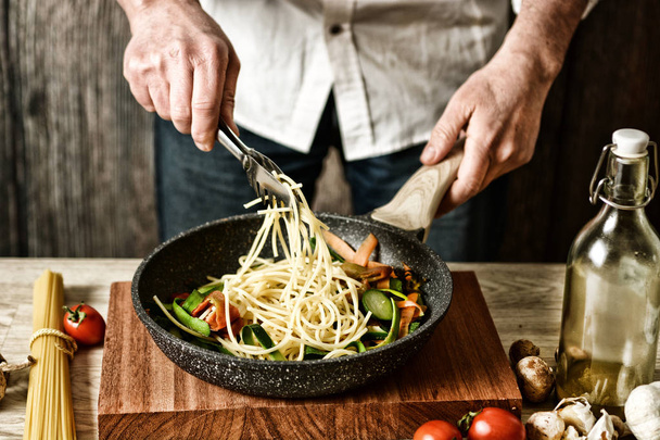 Espaguetis fritos con verduras variadas - receta italiana tradicional - enfoque selectivo - efecto desaturado - primer plano
 - Foto, imagen