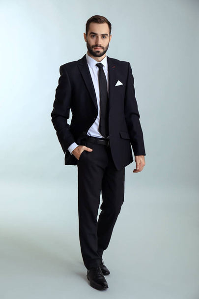 Handsome fashionable man in formal clothes against light background - Foto, Imagem