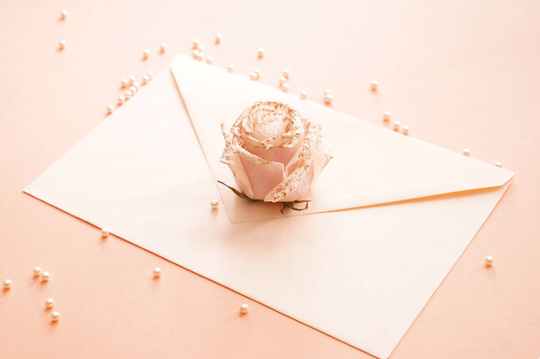 Sobre de papel con hermosa flor y perlas sobre fondo de color
 - Foto, Imagen