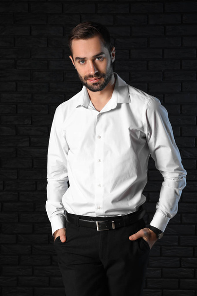 Handsome fashionable businessman against dark background - Photo, Image