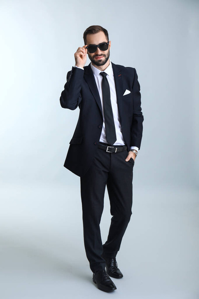 Handsome fashionable businessman against light background - Photo, image