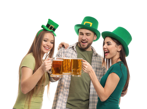 Νέοι άνθρωποι με πράσινα καπέλα και κούπες μπίρας σε άσπρο φόντο. Εορτασμός της ημέρας του Αγίου Πατρικίου - Φωτογραφία, εικόνα