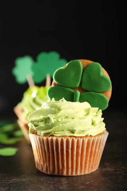 Tasty cupcakes and clover on table. Saint Patrick's Day celebration - Foto, Imagem