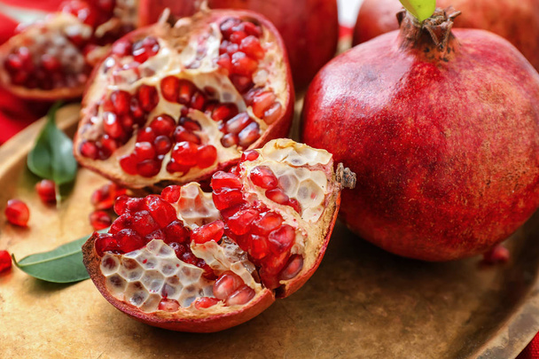Ripe pomegranates on metal tray - Фото, изображение
