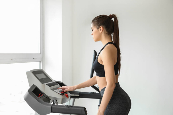 Sportliche junge Frau auf Laufband im Fitnessstudio - Foto, Bild