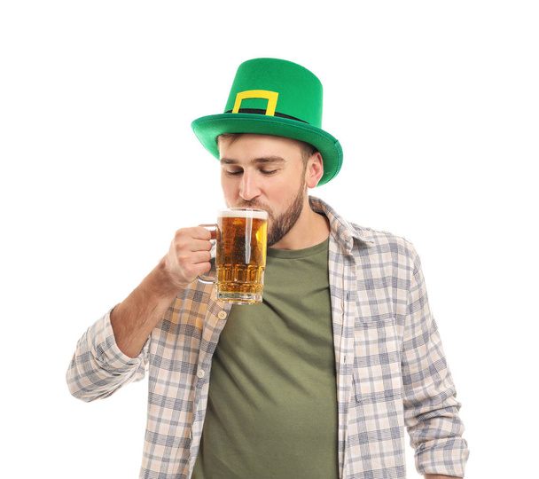 Przystojny, młody człowiek w zielonym kapeluszu picia piwa na białym tle. Obchody dnia Świętego Patryka - Zdjęcie, obraz
