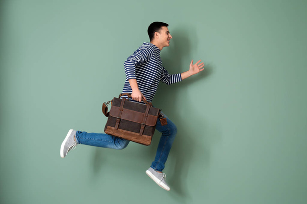 Hombre corriendo con maletín sobre fondo de color
 - Foto, Imagen