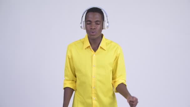 Young African businessman listening to music and looking guilty - Felvétel, videó
