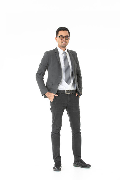 Full length portrait of young, handsome, Asian, businessman, wearing eyeglasses in business suit, standing, confidently look at camera, on isolated white background - Photo, Image