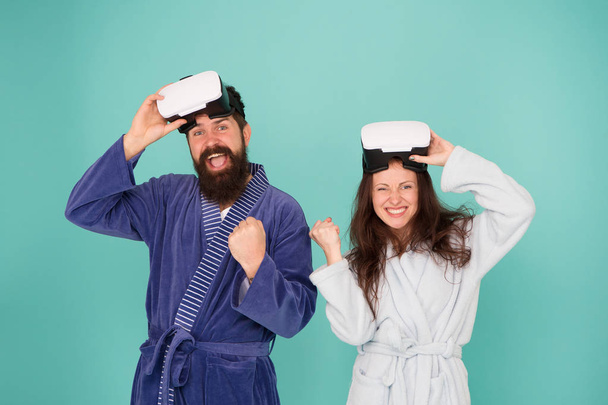 Man and woman explore vr. VR technology and future. VR communication. Exciting impressions. Awakening from virtual reality. Couple in bathrobes wear vr glasses. Conscious awakening. Return to reality - Foto, Imagem