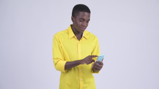 Young happy African businessman using phone and getting good news - Video