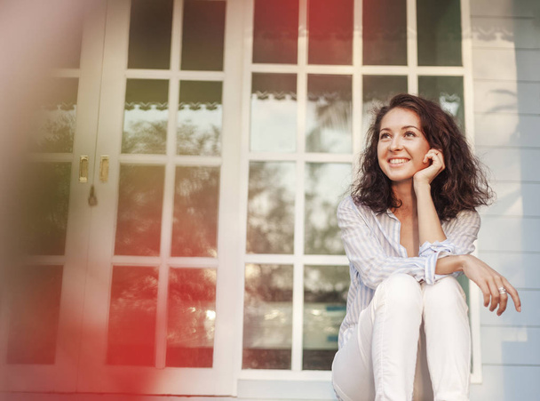 Muotokuva kaunis nuori nainen tummat hiukset istuu terassilla talonsa
 - Valokuva, kuva