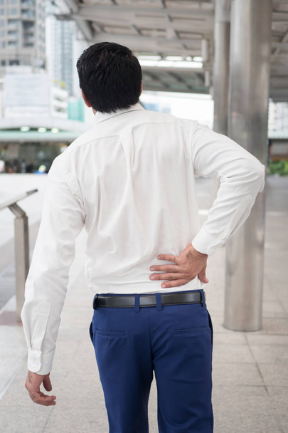 Sick unhealthy asian man suffering from back pain, spine problem, hernicated disc, spinal disc dislocation or displacement, office syndrome - Foto, Bild