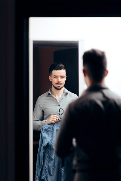 Stylish  Man Checking Himself in the Mirror Trying on Clothes - Фото, изображение