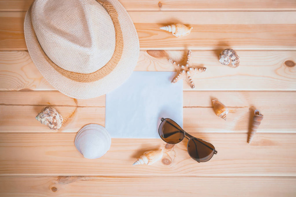 Hat, sunglasses, empty card for your text, starfishes and seashells on wooden background. Top view. Summer vacation concept. - Photo, Image