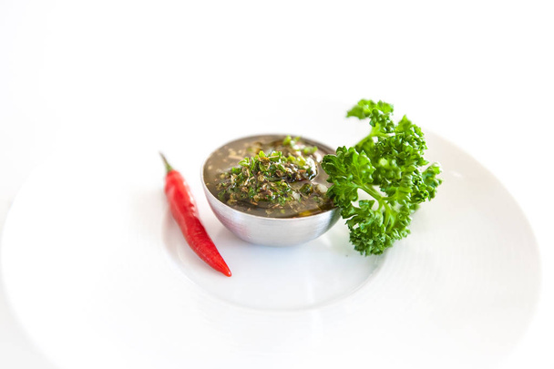Ruwe salsa voor zelfgemaakte groene Argentijnse Chimichurri of saus geïsoleerd op een witte achtergrond - Foto, afbeelding