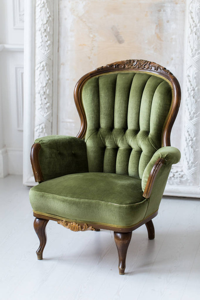 vintage luxury green armchair in white room over wall design bas-relief stucco mouldings roccoco elements - Foto, Imagen