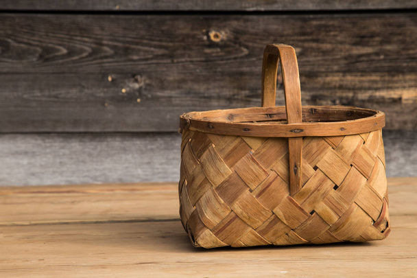 Ancient wicker basket on a wooden background. Selective focus. Free space for text. - Zdjęcie, obraz