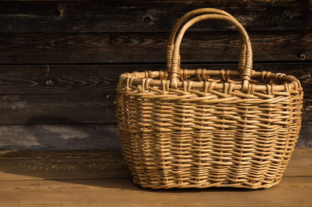 Ancient wicker basket on a wooden background. Selective focus. Free space for text - Fotoğraf, Görsel