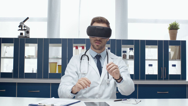 fehér kabátot, fárasztó fejhallgató vr és tapasztalt virtuális valóság klinikán férfi orvos - Felvétel, videó