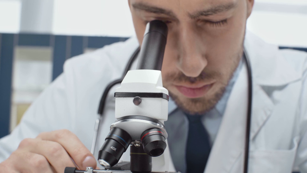 концентрированный ученый-мужчина, рассматривающий микроскоп в лаборатории
 - Кадры, видео
