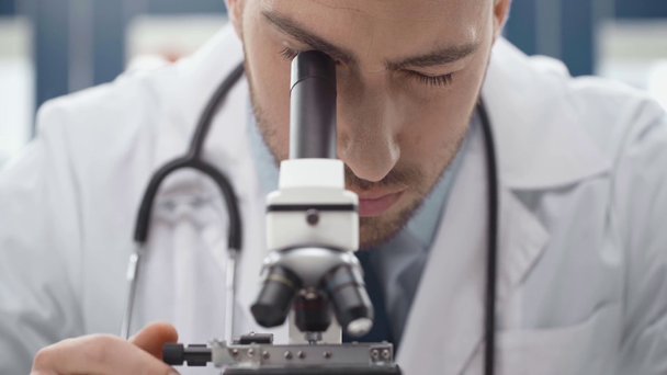 muž vědec v bílém plášti, Odhlédneme-li mikroskopem v laboratoři - Záběry, video