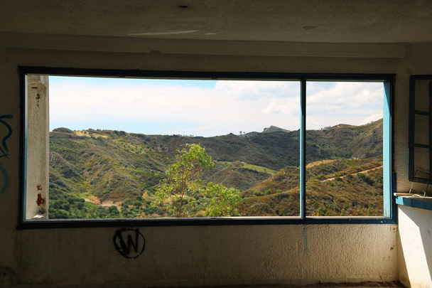 mooi landschap uit breed raam van een verlaten hotel. uitzicht vanuit het raam van vernietigde hotel in nea skioni village, kassandra schiereiland, chalkidiki - Foto, afbeelding