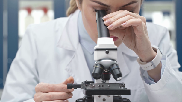 женщина-ученый в белом халате смотрит в микроскоп в лаборатории
 - Кадры, видео