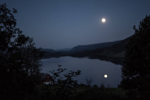 Μια σκοτεινή, μυστικιστική φεγγαρόλουστη λίμνη σε μια ήσυχη, ρομαντική Θαλασσογραφία τη νύχτα. - Φωτογραφία, εικόνα