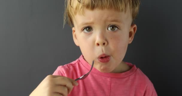 Χαριτωμένο μικρό αγόρι τρώει με πιρούνι - Πλάνα, βίντεο