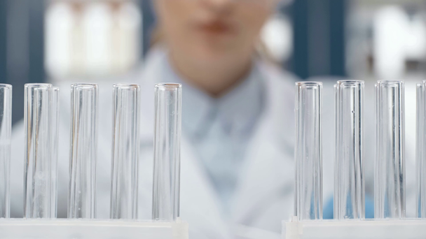 vista cortada de cientista fêmea escolhendo tubo de vidro em laboratório
 - Filmagem, Vídeo